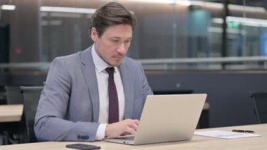 Bilgisayarlı Orta yaşlı İşadamı Kameraya Bakıyor 