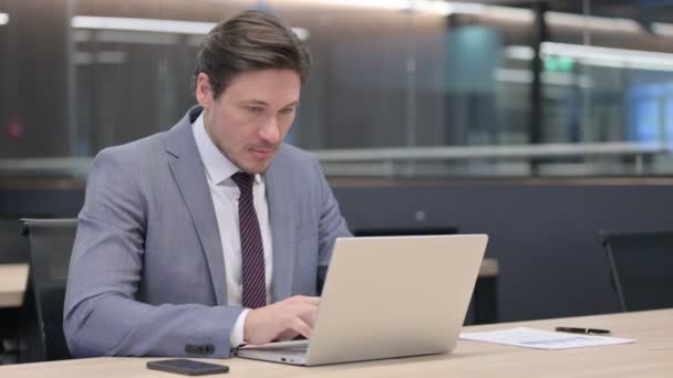Empresário de meia-idade com laptop celebrando no escritório — Vídeo de Stock