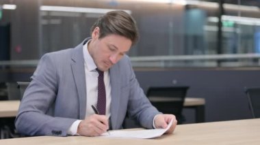 Orta Yaşlı Adam Belge İmzalıyor ve Hediye Veriyor 