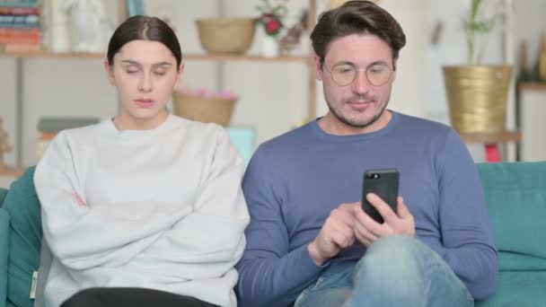 Latijnse vrouwen boos voelen naast mannelijke partner bezig met telefoon — Stockvideo