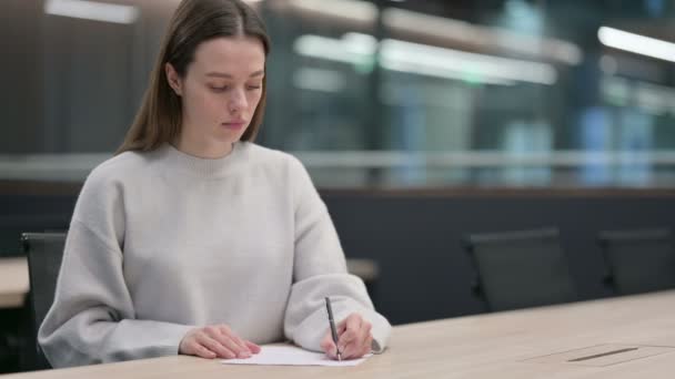 Belle femme écrivant sur papier au bureau — Video