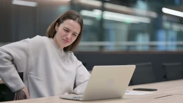 Жінка знову відчуває біль, користуючись ноутбуком — стокове відео