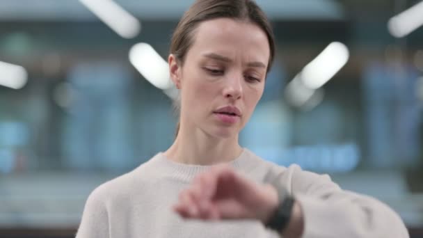 Retrato de mujer revisando reloj inteligente mientras espera — Vídeo de stock