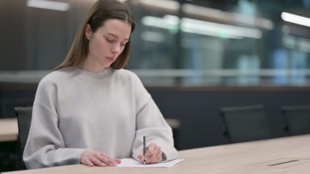 Femme attrayante écrivant sur le papier au bureau — Video