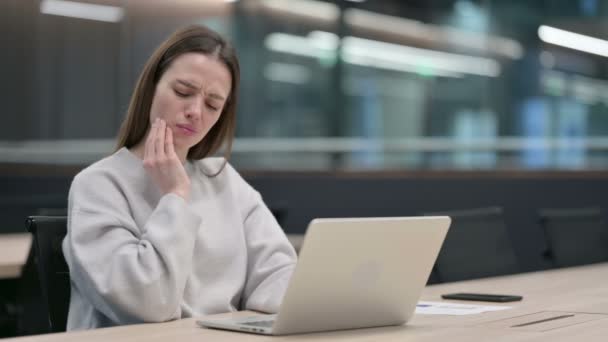 Femme ayant mal aux dents tout en travaillant sur ordinateur portable — Video