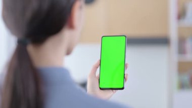 Yeşil Renkli Anahtar Ekranlı Akıllı Telefon kullanan Latin Kadın 