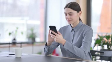 İş yerinde akıllı telefon kullanan Çekici Latin Kadın 