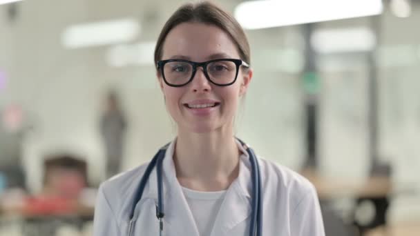 Портрет привабливого молодого лікаря, який посміхається перед камерою. — стокове відео