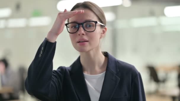 Porträt einer neugierigen jungen Geschäftsfrau, die sich umschaut und sucht — Stockvideo