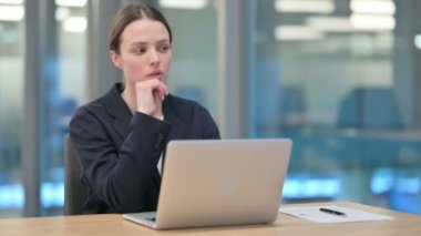 Genç İş Kadını İş yerinde Dizüstü bilgisayar kullanırken Düşünüyor 