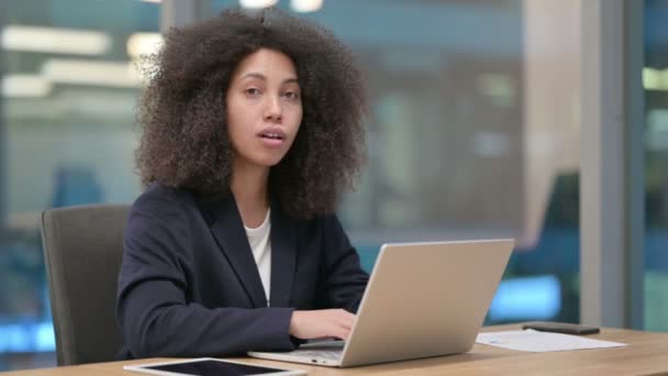 Afrikaans zakenvrouw met laptop wijzend op de camera — Stockvideo