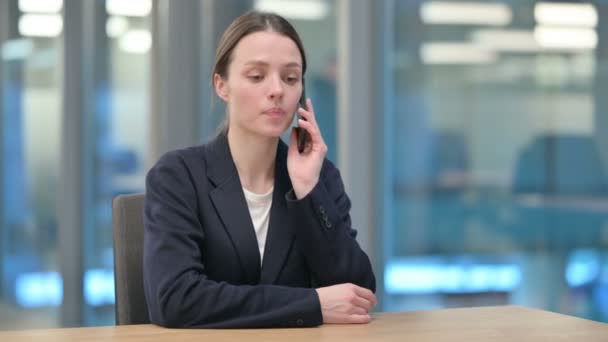 Fiatal üzletasszony beszél Smartphone a munkahelyen — Stock videók