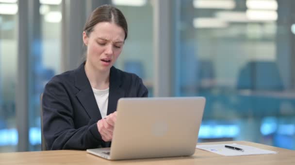 Ung affärskvinna som har ont i handleden när du skriver på laptop — Stockvideo