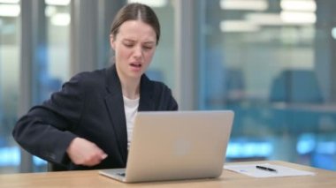 Genç iş kadını dizüstü bilgisayar kullanırken sırt ağrısı çekiyor 