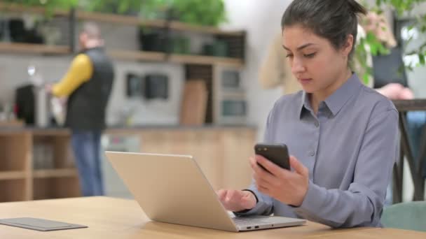 Mujer india con portátil usando Smartphone en el trabajo — Vídeos de Stock