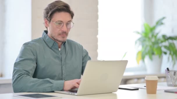 Pouces vers le bas par l'homme du Moyen Âge avec ordinateur portable dans le bureau — Video