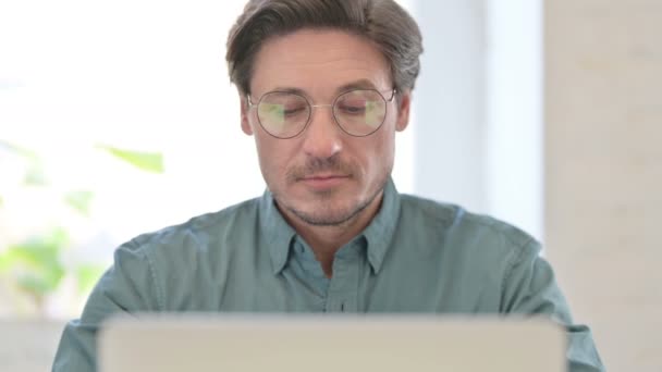 Portretul unui bărbat de vârstă mijlocie cu laptop zâmbind la cameră — Videoclip de stoc
