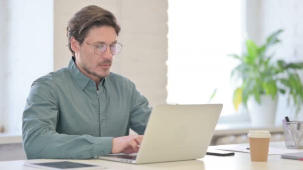 Homem de meia-idade com laptop com dor no pescoço — Vídeo de Stock