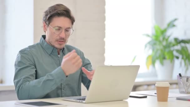 Мужчина средних лет с ноутбуком и болями в запястье — стоковое видео