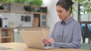 Dizüstü bilgisayar kullanırken bileği ağrıyan Hintli kadın 