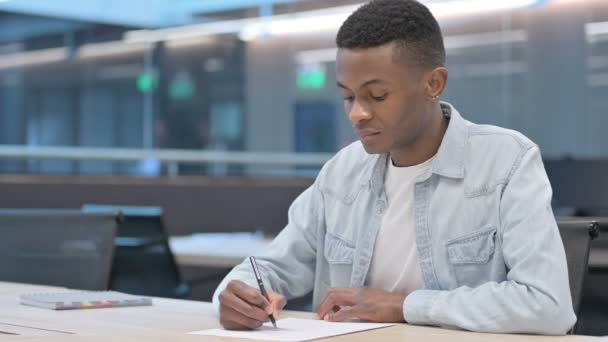 Hombre africano tratando de escribir en papel, fracaso — Vídeo de stock
