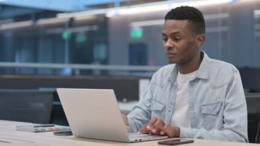 Dizüstü bilgisayarı olan Afrikalı adamın başı ağrıyor. 