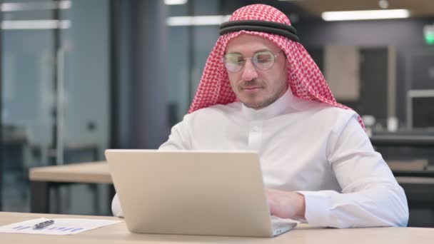 Hombre árabe de mediana edad con ordenador portátil diciendo que sí por sacudida de cabeza — Vídeo de stock