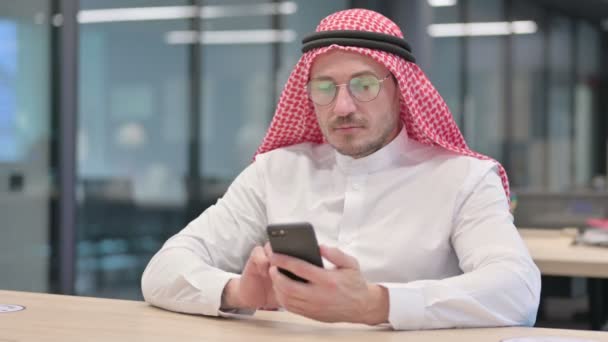Hombre árabe de mediana edad usando Smartphone en la oficina — Vídeos de Stock