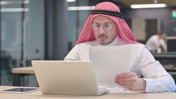 Middeleeuwse Arabische man met laptop viert succes op documenten — Stockvideo