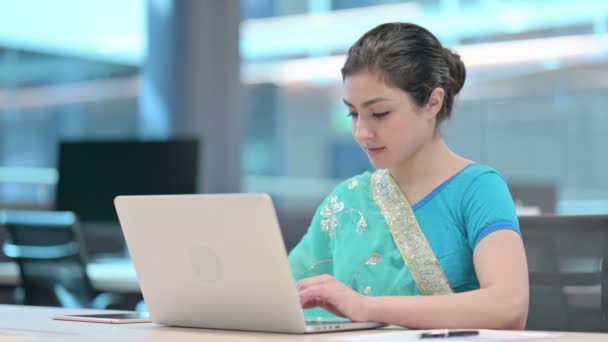 Молодая индийская женщина работает на ноутбуке в офисе — стоковое видео