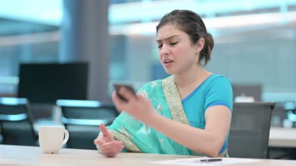 Mladá indická žena rozzlobený na smartphone v práci — Stock video