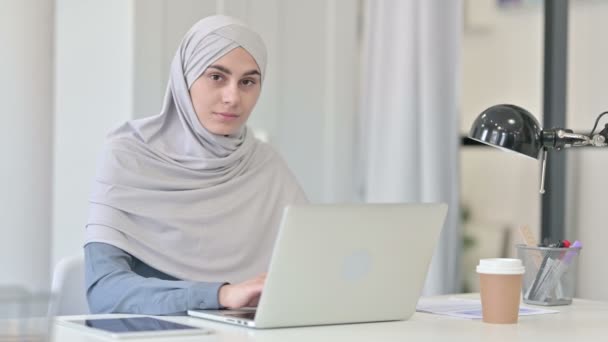 Mujer árabe joven con ordenador portátil diciendo no por sacudida de cabeza — Vídeo de stock