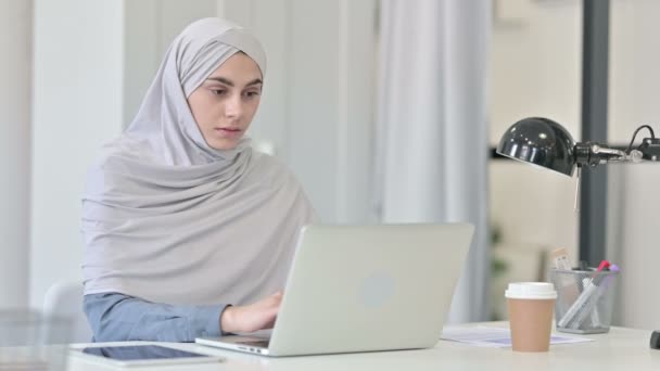 Jeune femme arabe Penser tout en utilisant un ordinateur portable au bureau — Video