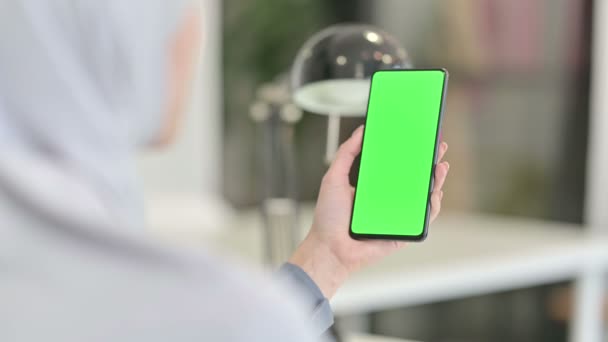 Junge Araberin blickt mit Chroma-Schlüsselbildschirm auf Smartphone — Stockvideo