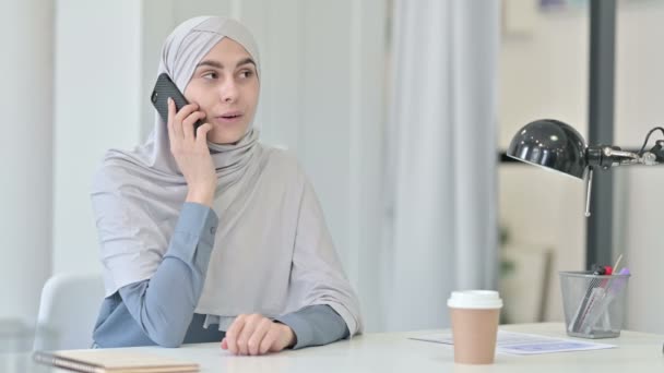 Молодая арабка разговаривает по смартфону в офисе — стоковое видео