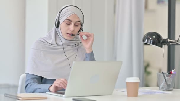 Młoda Arabka z laptopem rozmawiająca na słuchawkach — Wideo stockowe