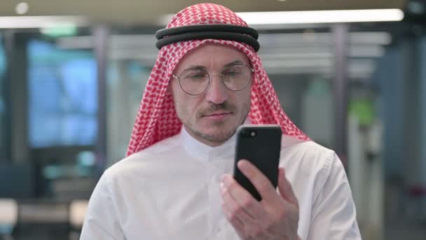 Hombre árabe de mediana edad celebrando en Smartphone — Vídeos de Stock
