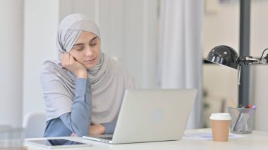Dizüstü bilgisayarlı genç Arap Kadın Ofiste Kestiriyor 