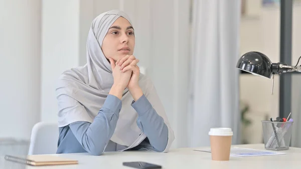 Jonge Arabische vrouw denkend terwijl ze op kantoor zit — Stockfoto