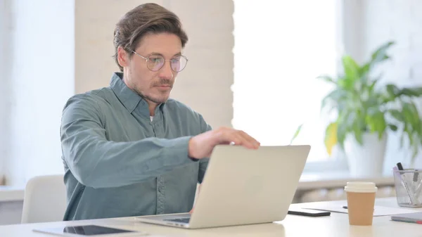 Hombre de mediana edad que cierra el ordenador portátil que se aleja de la oficina —  Fotos de Stock
