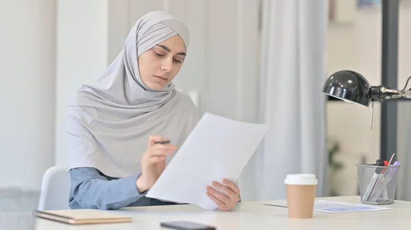 Jonge Arabische vrouw die documenten aan het lezen is — Stockfoto