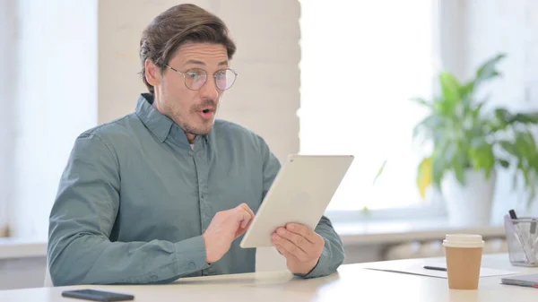 Hombre de mediana edad reaccionando a la pérdida en la tableta — Foto de Stock