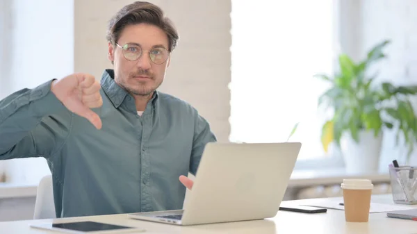 Pouces vers le bas par l'homme du Moyen Âge avec ordinateur portable dans le bureau — Photo