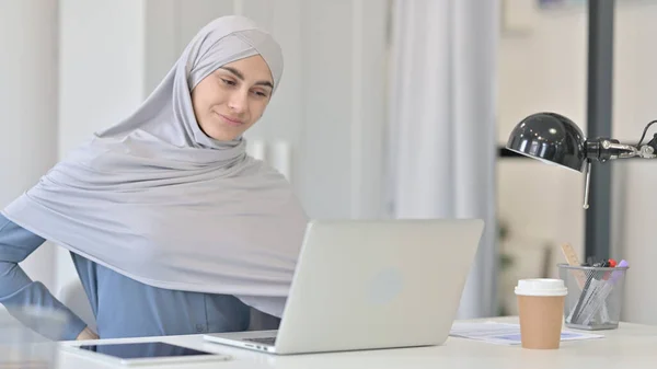 Jovem mulher árabe com laptop tendo dor nas costas — Fotografia de Stock
