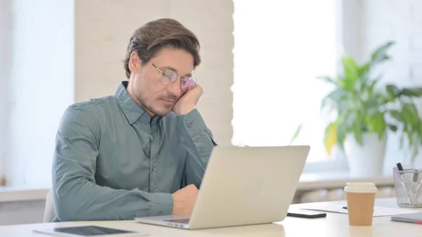 Чоловік середнього віку з ноутбуком приймає Nap в офісі — стокове фото