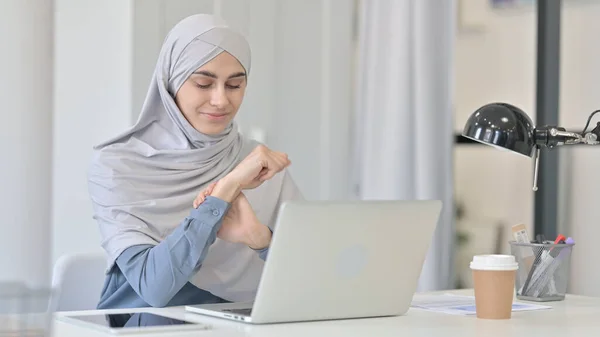 Jonge Arabische vrouw met laptop met pijn in de pols — Stockfoto