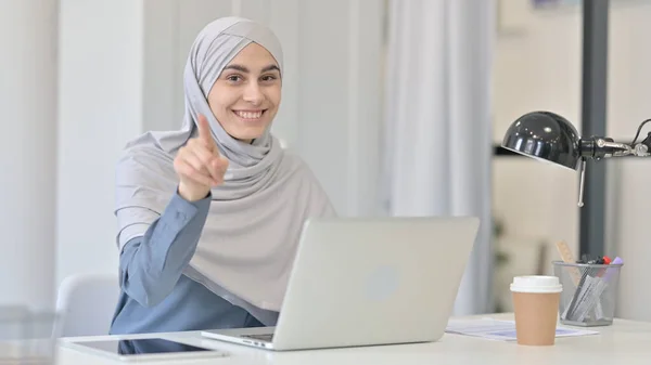 Jonge Arabische vrouw met laptop wijst naar de camera — Stockfoto