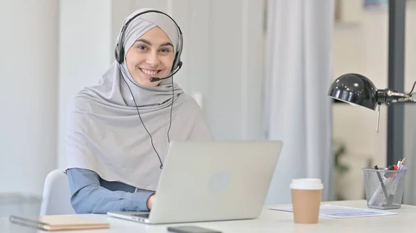 Mulher árabe jovem com laptop sorrindo com fone de ouvido — Fotografia de Stock