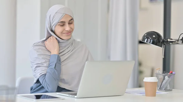 Mulher árabe jovem com laptop com dor no pescoço — Fotografia de Stock