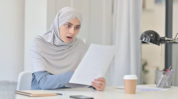 Jonge Arabische vrouw reageert op verlies tijdens het lezen van documenten — Stockfoto